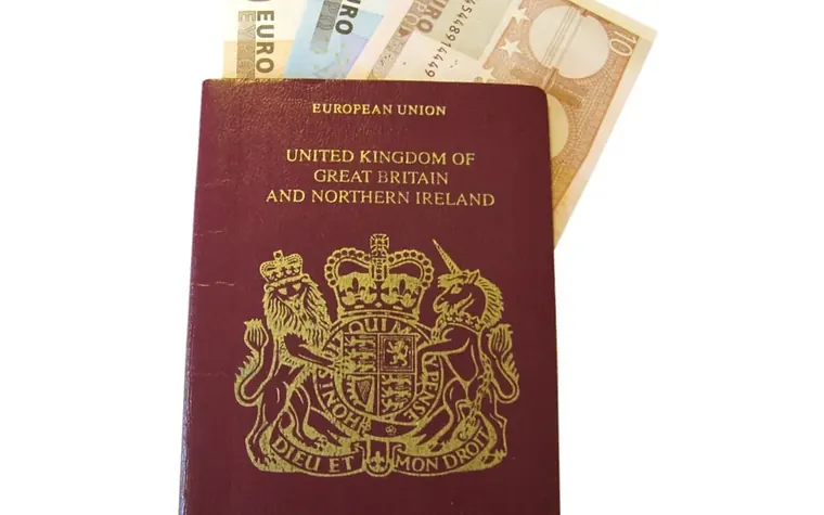 Passeport posé devant plusieurs billets en euros pour préparer un budget de voyage