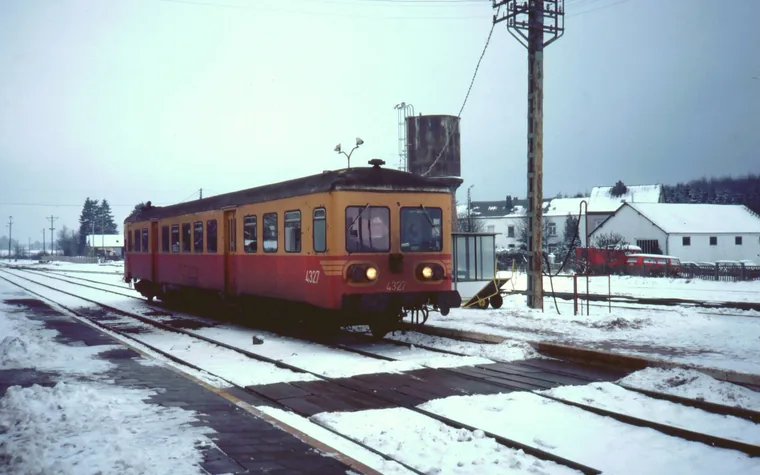 Autorail rouge et jaune sur une voie enneigée à Bertrix