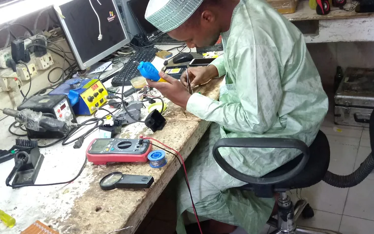 Technicien réparant une clé électronique sur un établi