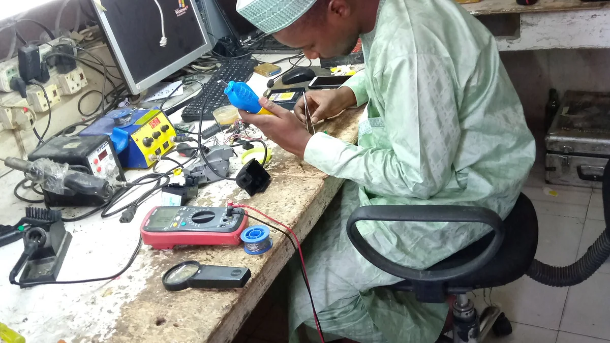 Technicien réparant une clé électronique sur un établi